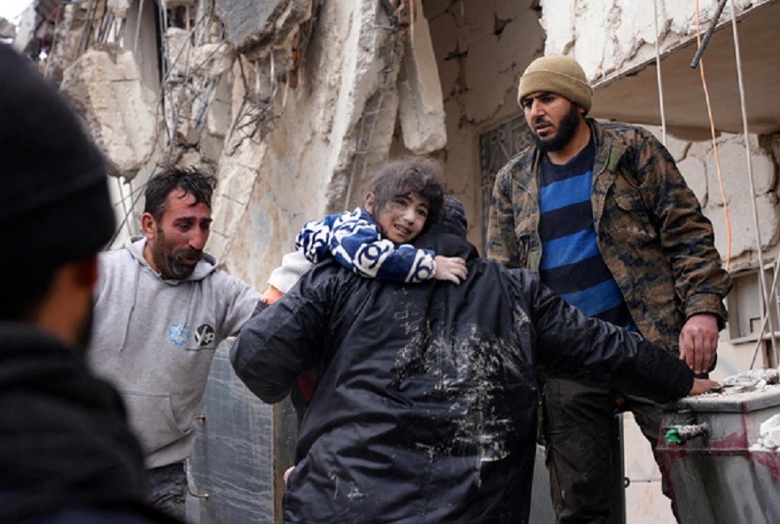 Vecinos rescatan a un niño pequeño que había quedado entre los escombros en la ciudad de Afrin (Siria)
