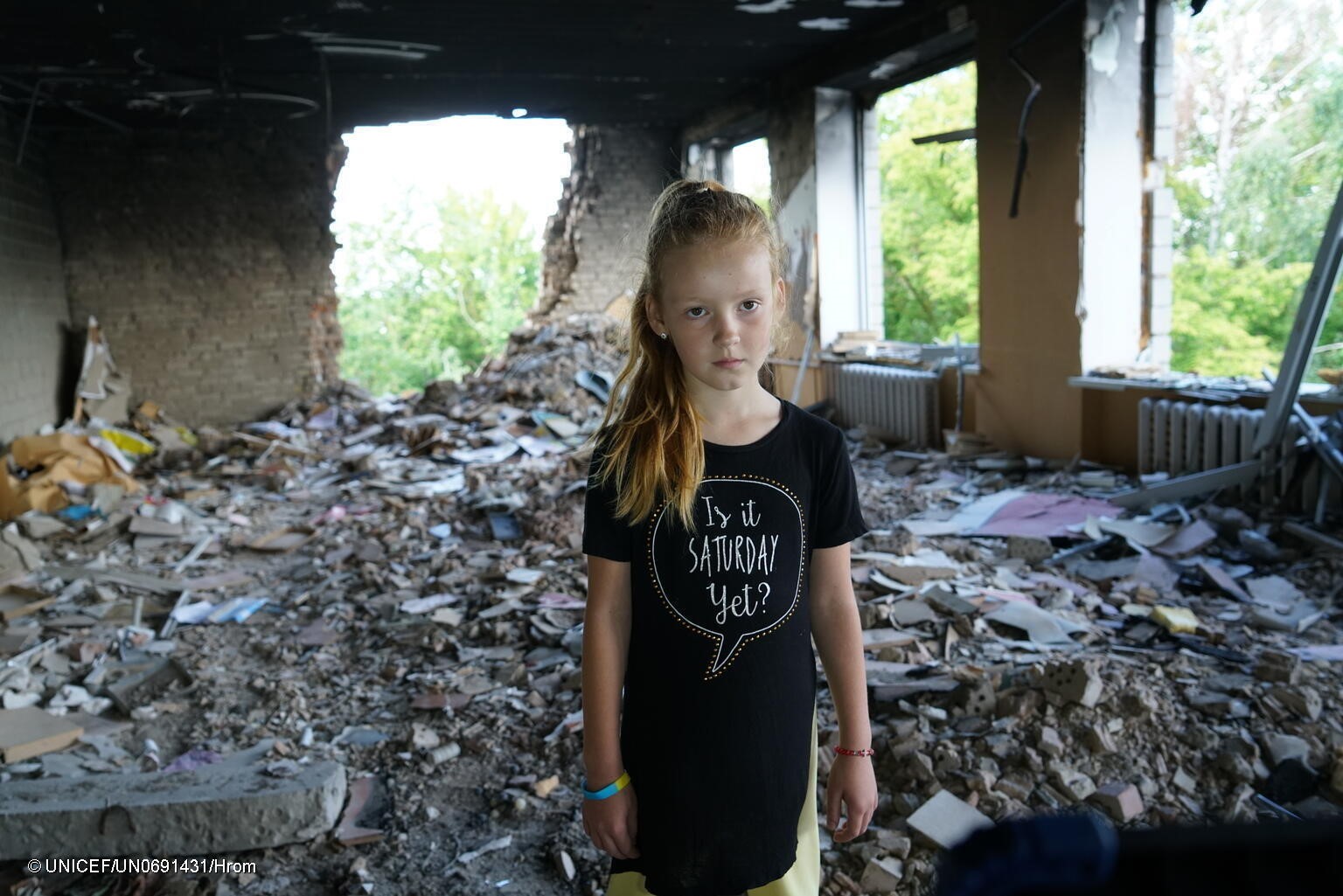 Una niña frente a las ruinas de su escuela en Ucrania