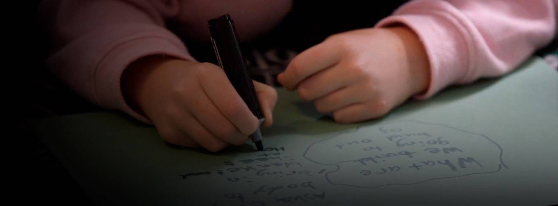 Únete al programa de UNICEF para centros educativos Un niño escribiendo