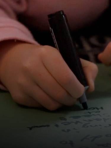 Únete al programa de UNICEF para centros educativos Un niño escribiendo