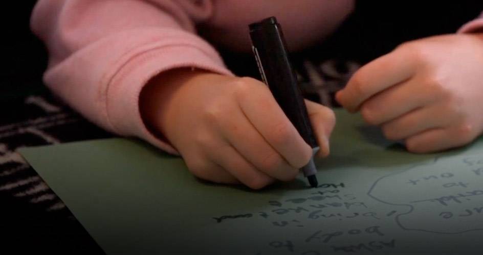 Únete al programa de UNICEF para centros educativos Un niño escribiendo