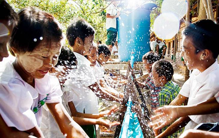 Varios niños felices lavándose las manos