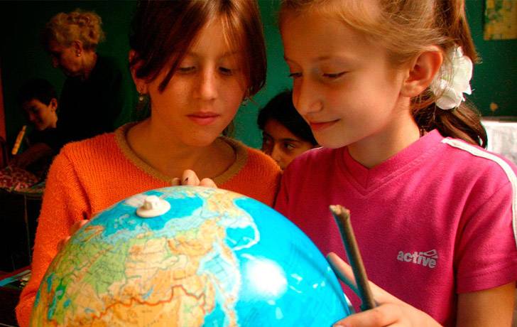 Educación en derechos Imagen de dos niñas mirando un globo terráqueo