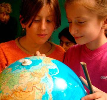 Educación en derechos Imagen de dos niñas mirando un globo terráqueo