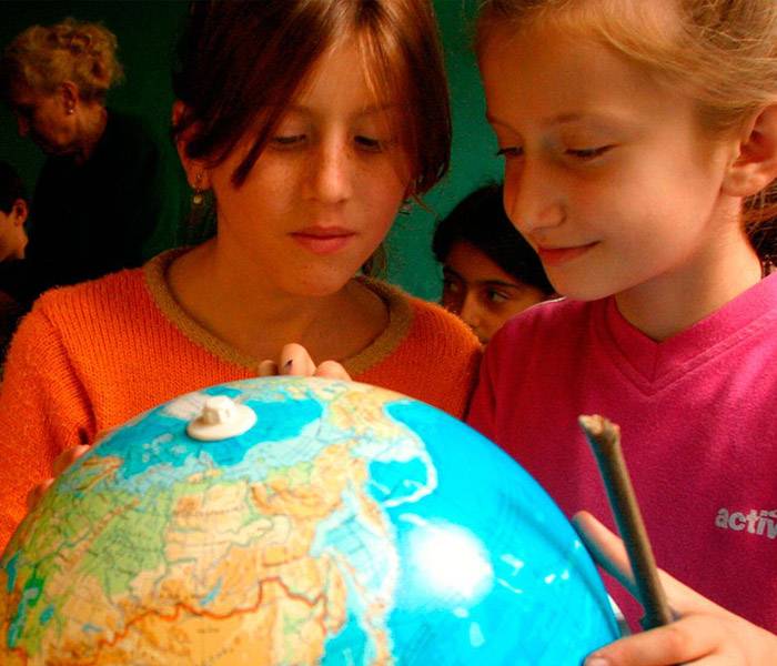 Educación en derechos Imagen de dos niñas mirando un globo terráqueo