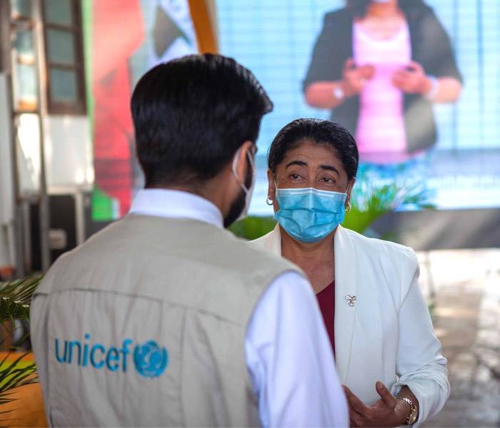 Defendemos los derechos de los niños y niñas en todo el mundo Trabajadora de UNICEF dialogando