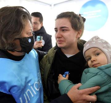 Conflicto en Ucrania: 7,3 millones de niños y niñas de Ucrania necesitan ayuda urgente. Una madre con su hija en brazos en uno de los puntos azules de UNICEF ayudada por una trabajadora