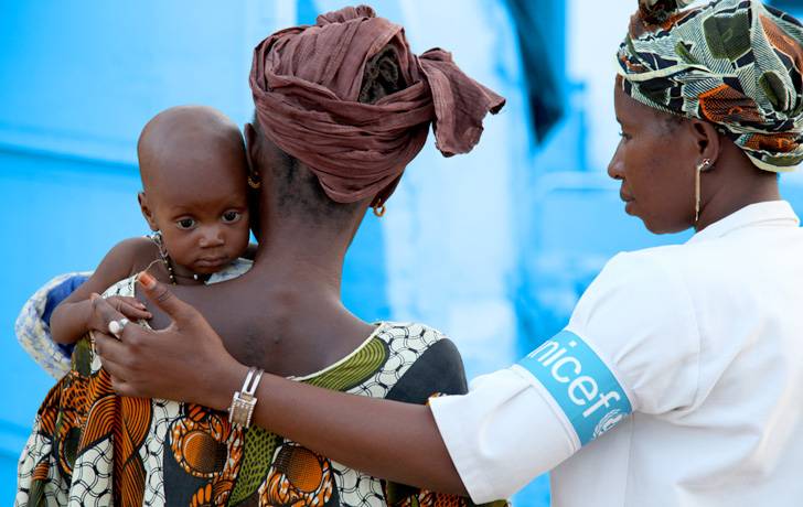 Sin tu colaboración todo esto no sería posible. Una colaboradora UNICEF ayuda a una madre con su bebé