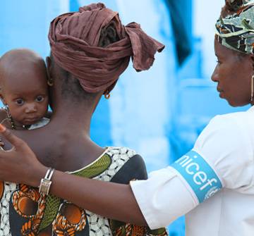 Sin tu colaboración todo esto no sería posible. Una colaboradora UNICEF ayuda a una madre con su bebé