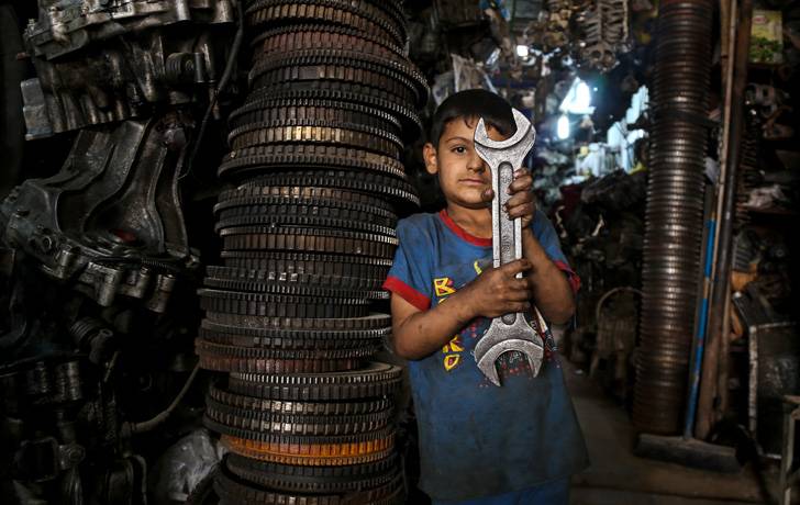 Mustafa, de 6 años, trabaja con su padre en una zona industrial de Bagdad.