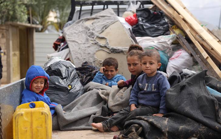 Niños durante su desplazamiento en Rafah Niños sentados en la parte trasera de un camión