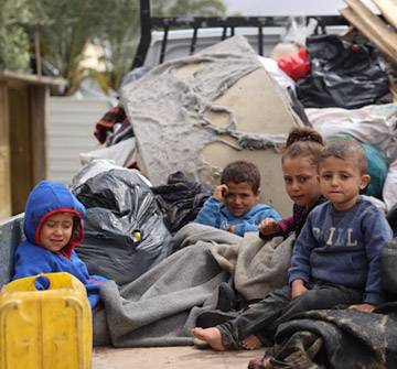 Niños durante su desplazamiento en Rafah Niños sentados en la parte trasera de un camión
