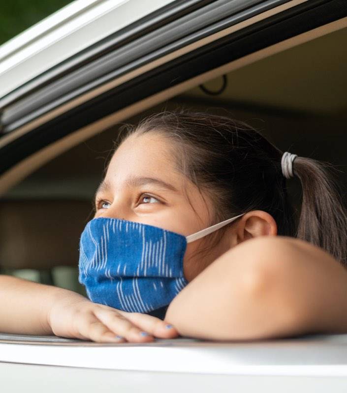 Imagen de una niña mirando por la ventana de un coche