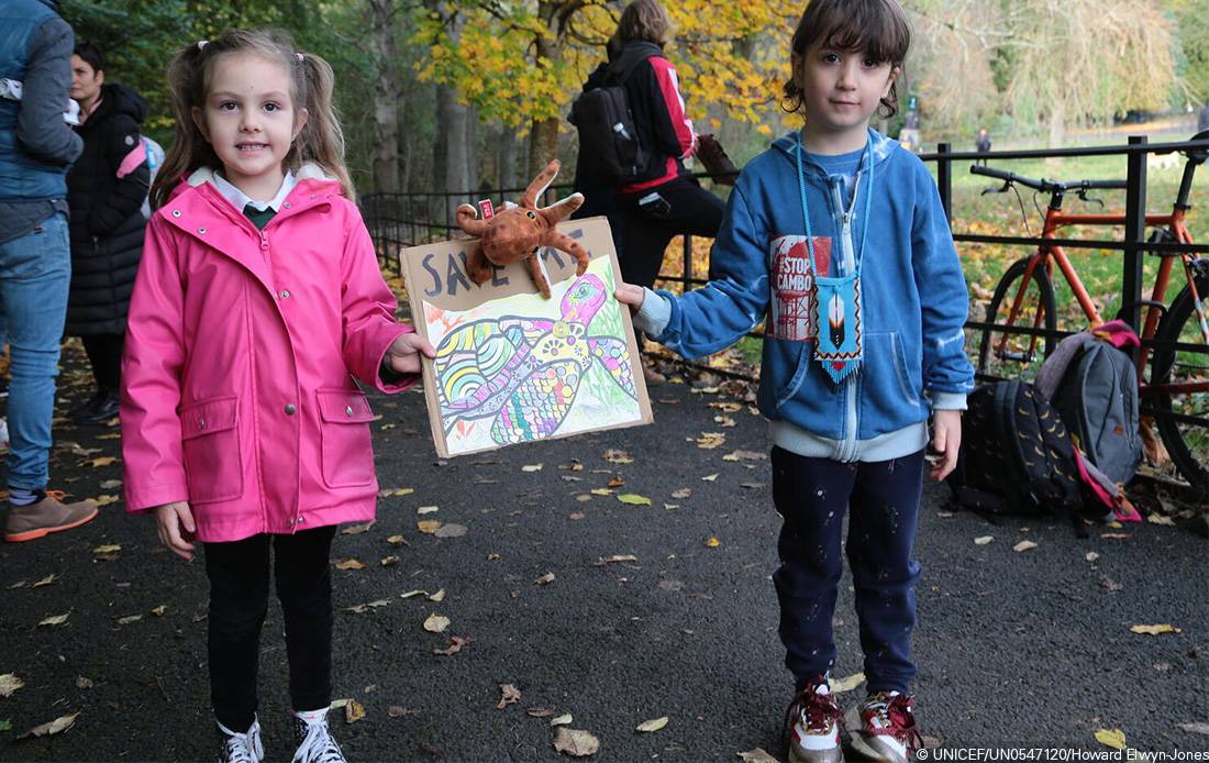 Dos niñas muestran un cartel sobre la protección del medioambiente hecho por ellas