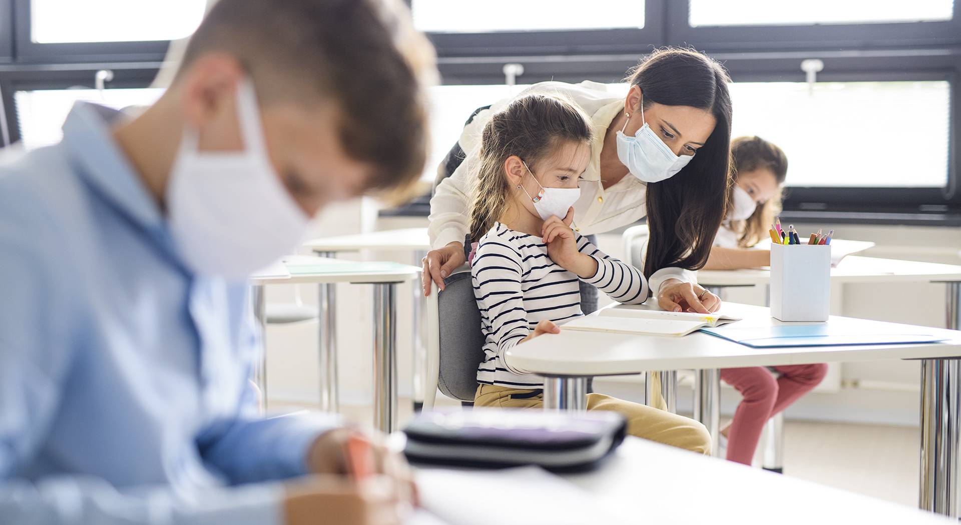 Una docente atiende a una alumna en el aula